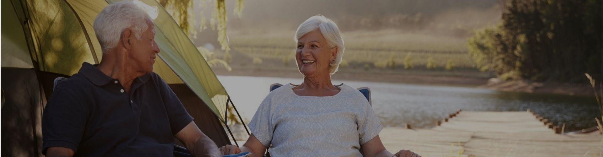 senior couple enjoying their campsite at a beautiful lake